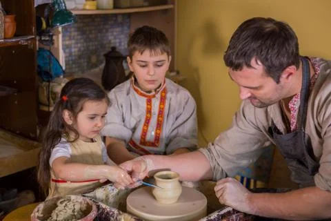 Potter showing how to work with ceramic in pottery studio Stock Photos