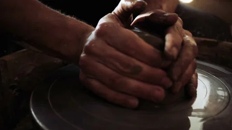 The potter throws and fixes the clay on the potter's wheel and begins work. Stock Footage 159970103