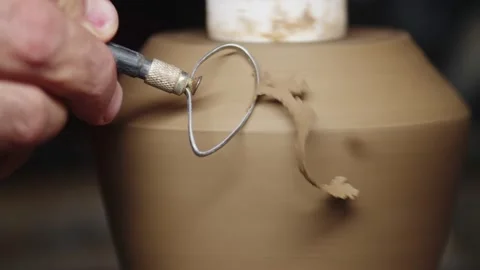 Potter use cutter with which he removes thin shavings from raw clay vase Stock Footage 161073719