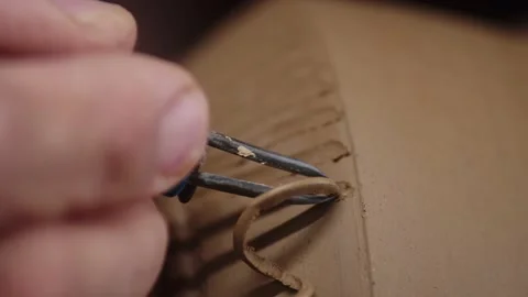 Potter uses ribbon tool with which makes pattern on clay vase, closeup Stock Footage 170377150