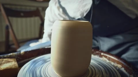 A potter using a potter's wheel making a vase Stock Footage 278311009