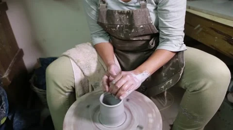 Potter at work creating clay bowl on turning wheel Stock Footage 61932537