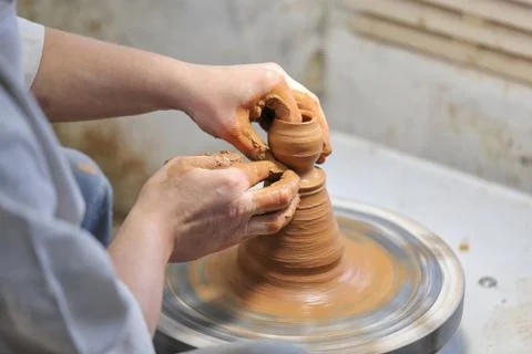 Potter at work. Potter making a pitcher of clay on a pottery wheel. 库存照片