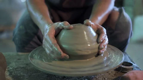 Potter working on potters wheel making ceramic pot from clay in pottery workshop Stock Footage 158968712