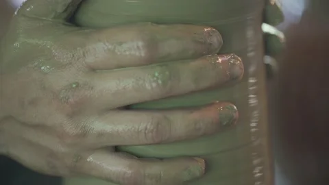 Potter working on potters wheel making ceramic pot from clay in pottery workshop Stock Footage 158969366