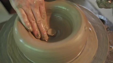 Potter working on potters wheel making ceramic pot from clay in pottery workshop Stock Footage 158969571