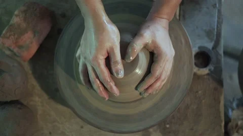 Potter working on potters wheel making ceramic pot from clay in pottery workshop Stock Footage 158970060