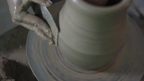 Potter working on potters wheel making ceramic pot from clay in pottery workshop Stock Footage 158970132