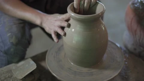 Potter working on potters wheel making ceramic pot from clay in pottery workshop Stock Footage 158970332