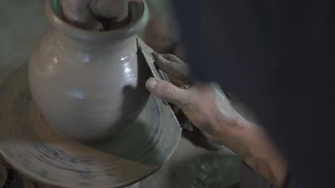 Potter working on potters wheel making ceramic pot from clay in pottery workshop Stock Footage 158970608