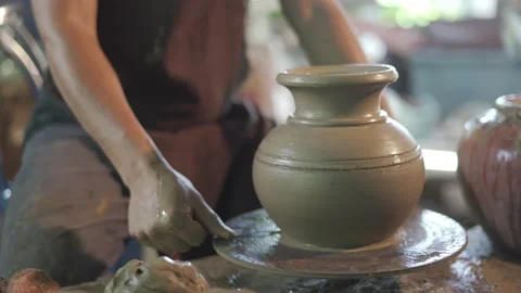 Potter working on potters wheel making ceramic pot from clay in pottery workshop Stock Footage 158970795