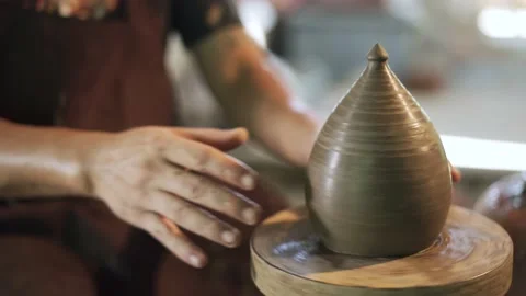 Potter working on potters wheel making ceramic pot from clay in pottery workshop Stock Footage 158971090