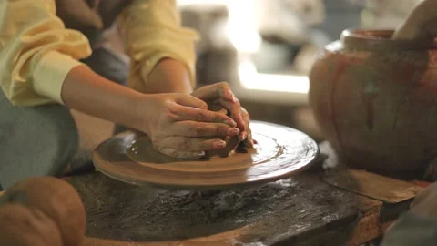 Potter working on potters wheel making ceramic pot from clay in pottery workshop Stock Footage 158973787