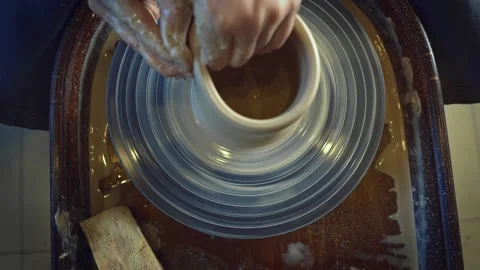 Potter working on a Potter's wheel making a vase Stock Footage 278310893