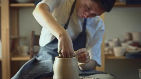Potter working on a Potter's wheel making a vase Stock Footage 278311307