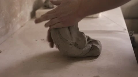 Potter working in studio kneading clay Stock Footage 235465739