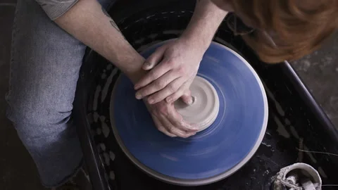 Potter working in studio throwing pots on wheel Stock Footage 235466513