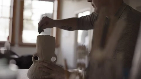 Potter working in studio throwing pots on wheel Stock Footage 235466677