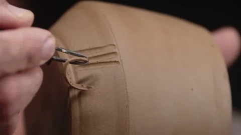 Potter's hand cuts out patterns in form of sticks on smooth clay product with Stock Footage 158977995