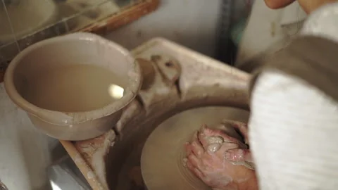 Potter's hands grabbing a sponge to clean the wheel's edges for a tidy work.. Stock Footage 274164332