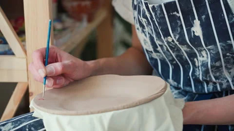 A potter's hands paint a ceramic plate with a brush. Close up 库存影片 234849264