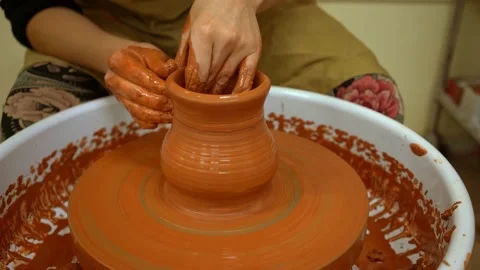 Potter's hands shape a clay jug on a rotating potter's wheel (Close-up) Stock Footage 148178909