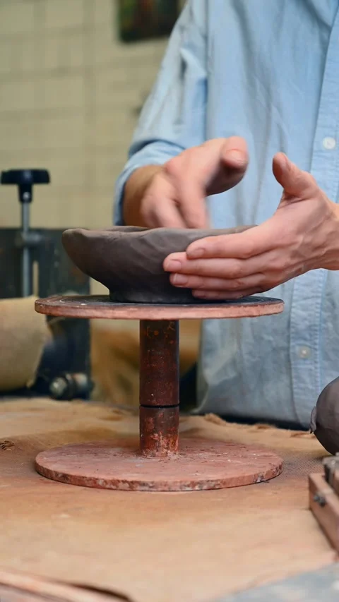 Potter's wheel for hand work, Master makes a plate by hand. Vertical format Stock Footage 294107641