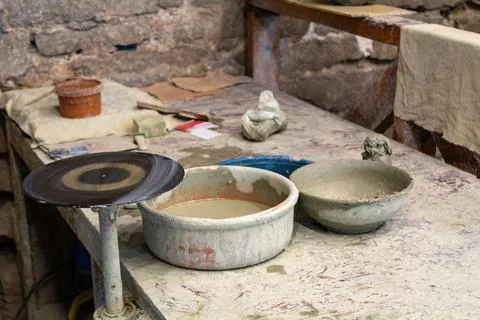 Potter's workshop. A working table with clay and a potter's wheel. Stock Photos
