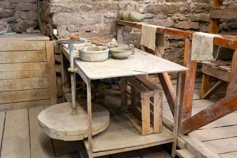 Potter's workshop. A working table with clay and a potter's wheel. Stock Photos
