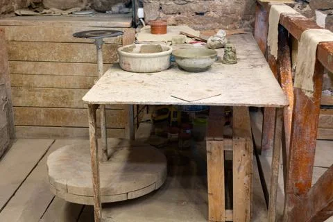 Potter's workshop. A working table with clay and a potter's wheel. Stock Photos