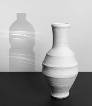 Pottery drinking jar with shadow of a plastic water bottle Stock Photos