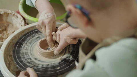 Pottery instructor guiding a child s hands on a pottery wheel. Learning ceramic Stock Footage 303515697