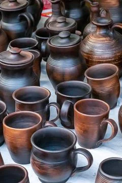 Pottery pattern dark brown set mug and jug standing on counter at rural fair Stock Photos