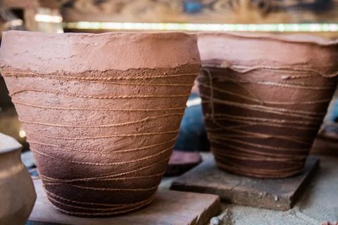 In the pottery shop, the sun's rays fall on the pottery. A clay pot and a jug Stock Photos