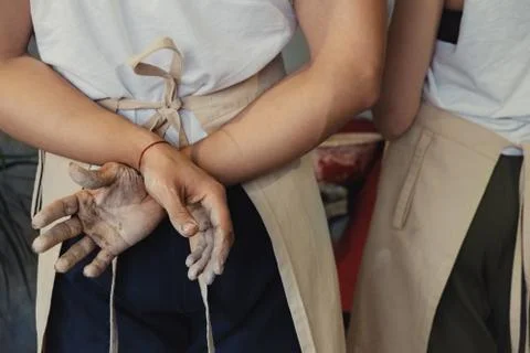 Pottery students with hands in clay learning from their master ceramist Stock Photos