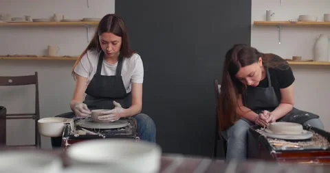 Pottery studio concept. Two young woman using pottery wheel, handmade ceramics Stock-Footage 155463101