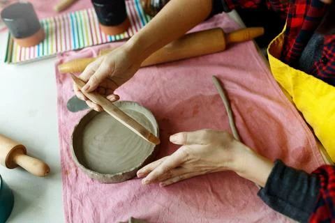 Pottery workshop class. A pottery crafts dish from a raw clay. Creating ceramics 스톡 사진