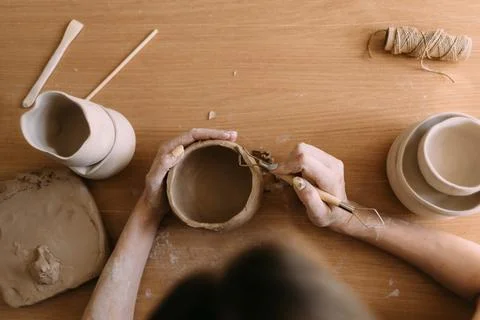 Pottery in workshop clay art concept. close-up on the hands of a young cerami Stock Photos