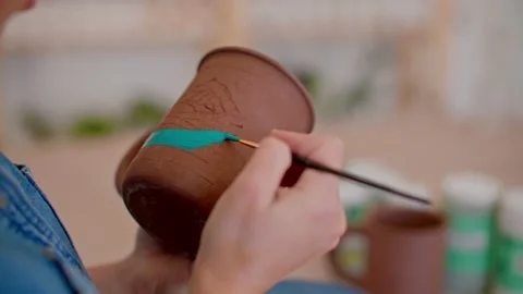 Pottery workshop, close up of hands painting mug 库存影片 221949874