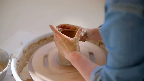Pottery workshop, close up of hands shaping clay mug on pottery wheel 库存影片 221949825