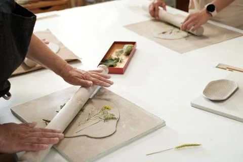 Pottery workshop in cozy studio hands working with clay, rolling plants Foto stock
