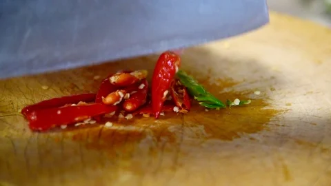 Pound the red chilli by cleaver on wood plate Video stock 108577120
