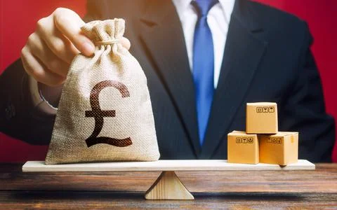 Pound sterling GBP symbol money bag and a bunch of boxes on scales. Trade e.. Stock Photos