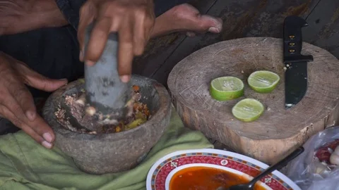 Pounding chill paste with an old stone mortar Stock Footage 128471501