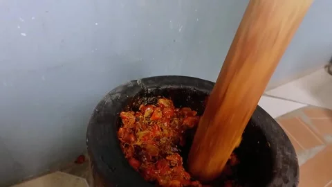Pounding palm nuts using a wooden mortar and pestle. Stock Footage 316110182