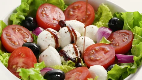 Pour balsamic vinegar dressing on fresh homemade vegetarian salad. Cooking Stock Footage 154941928