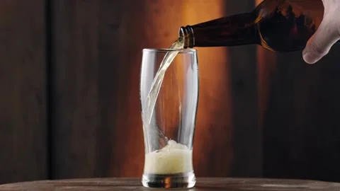 Pour beer from the bottle to the last drop Pouring cold beer into glass. Stock Footage 265765408