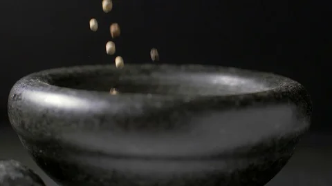 Pour black and white pepper into a mortar. Slow motion Stockbeeldmateriaal 105618161