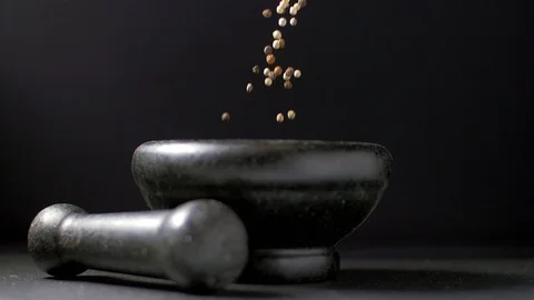 Pour black and white pepper into a mortar. Slow motion Видео 105618250