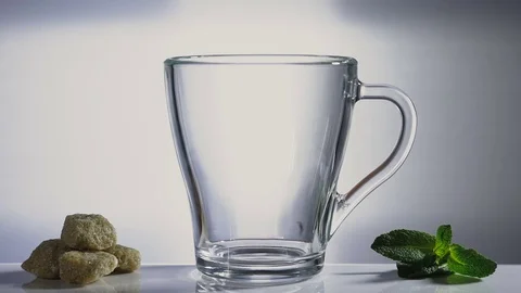 Pour boiling water over the tea leaves. Sugar and leaves of mint Stockbeeldmateriaal 73276415